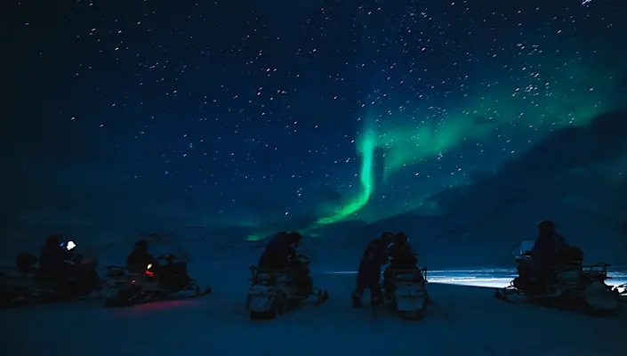 Northern lights hunting with electric snowmobile - Hurtigruten Svalbard - Photo Agurtxane Concellon