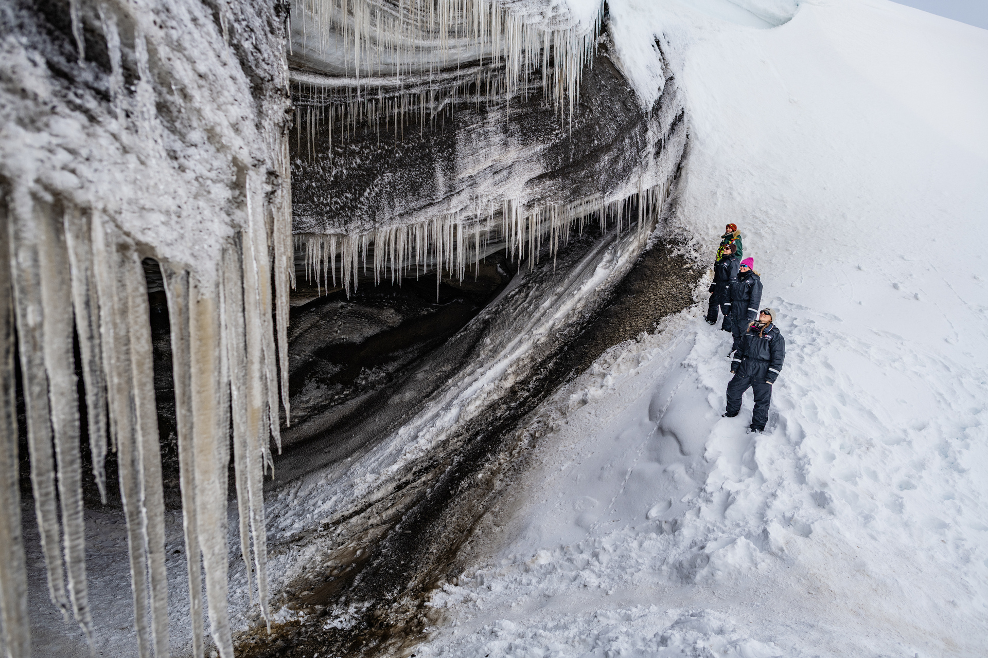 Guests viewing a glacier and its hanging icicles