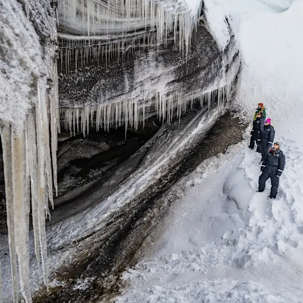 Guests viewing a glacier and its hanging icicles