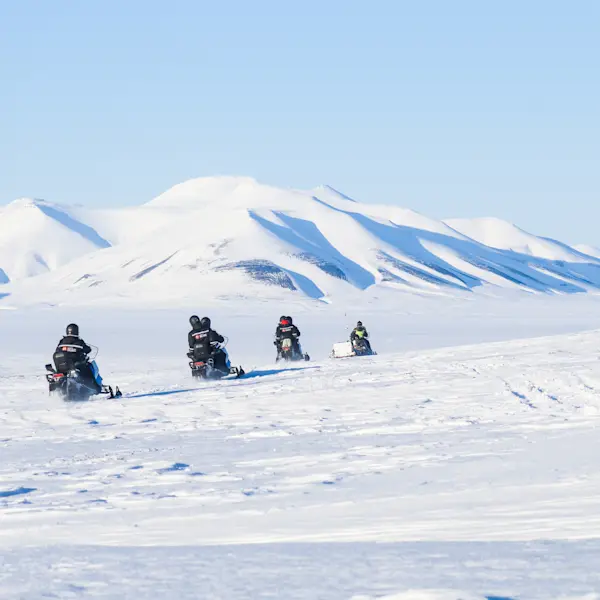 Snowmobile tour across the snow on Svalbard. Photo Credit: Eveline Lunde / Hurtigruten Svalbard