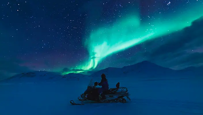 Northern light and snow mobile - Hurtigruten Svalbard - Photo Agurtxane Concellon