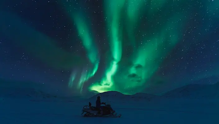 Northern lights and snow electric mobile - Hurtigruten Svalbard - Photo Agurtxane Concellon