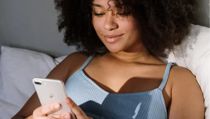 Woman using mobile phone while smiling