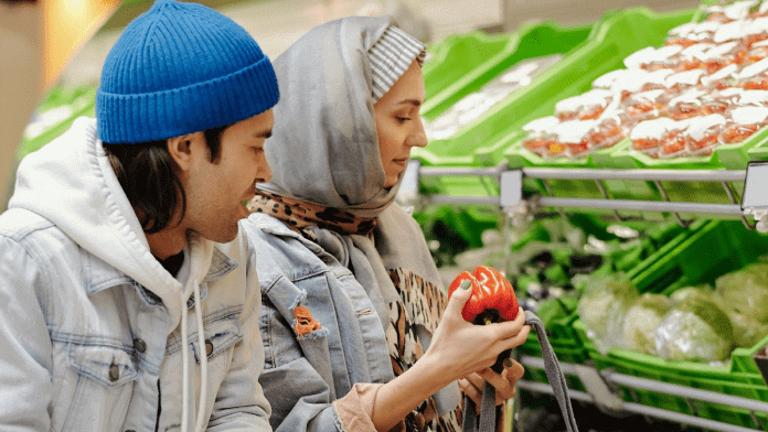 Son helping mother grocery shop in produce aisle