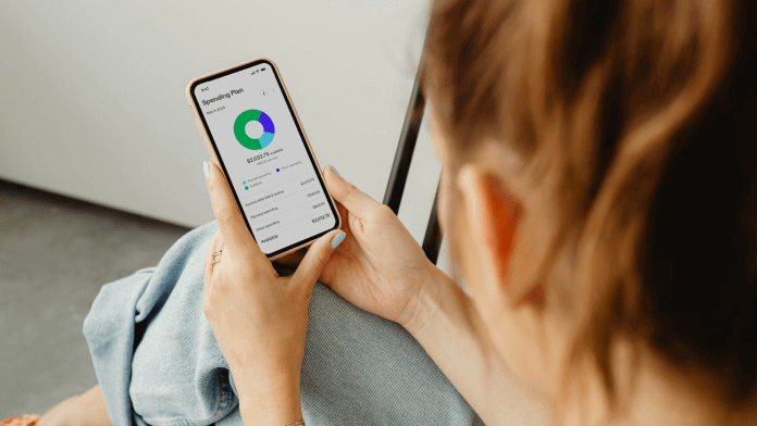woman using Simplifi spending plan pie chart user interface on mobile phone