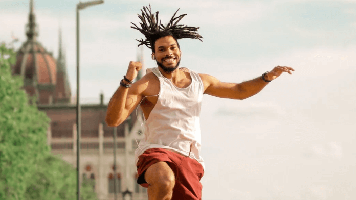 Man smiling while jumping in the air outside