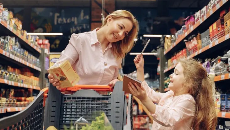 Mother and daughter shopping at grocery store together