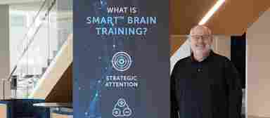 Bob Priest-Heck at the center, standing beside a SMART banner (Feb. 2022).