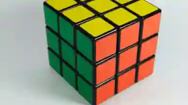 A solved red, green and yellow rubic's cube on a white background