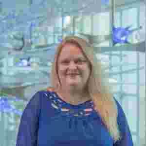 Lori Cook in a blue blouse with blue lights, vertical. Director of Clinical Research, BrainHealth Research; Head of Research, The BrainHealth Project; Adjunct Assistant Professor, School of Behavioral and Brain Sciences