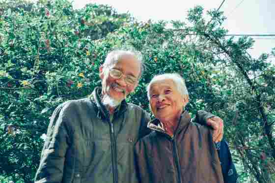 Elderly couple smiling, outdoors on a beautiful day. 