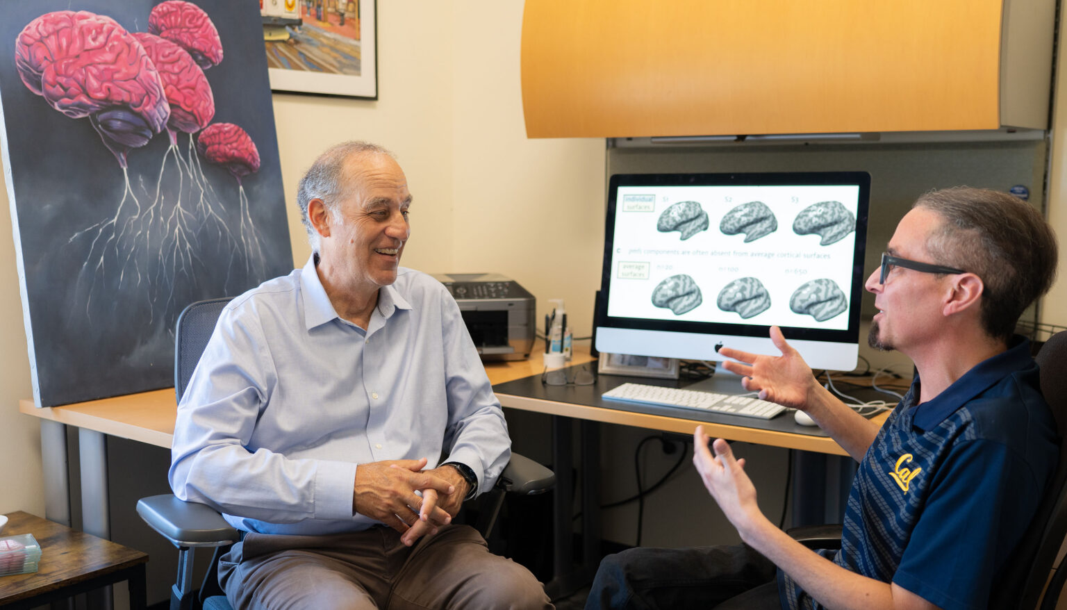Dr. Mark D’Esposito (left) and Kevin Weiner discussing Weiner’s research on grooves and folds in the human brain and how they relate to cognitive function and a healthy brain. Photo Credit: Brandon Sanchez Mejia for UC Berkeley.