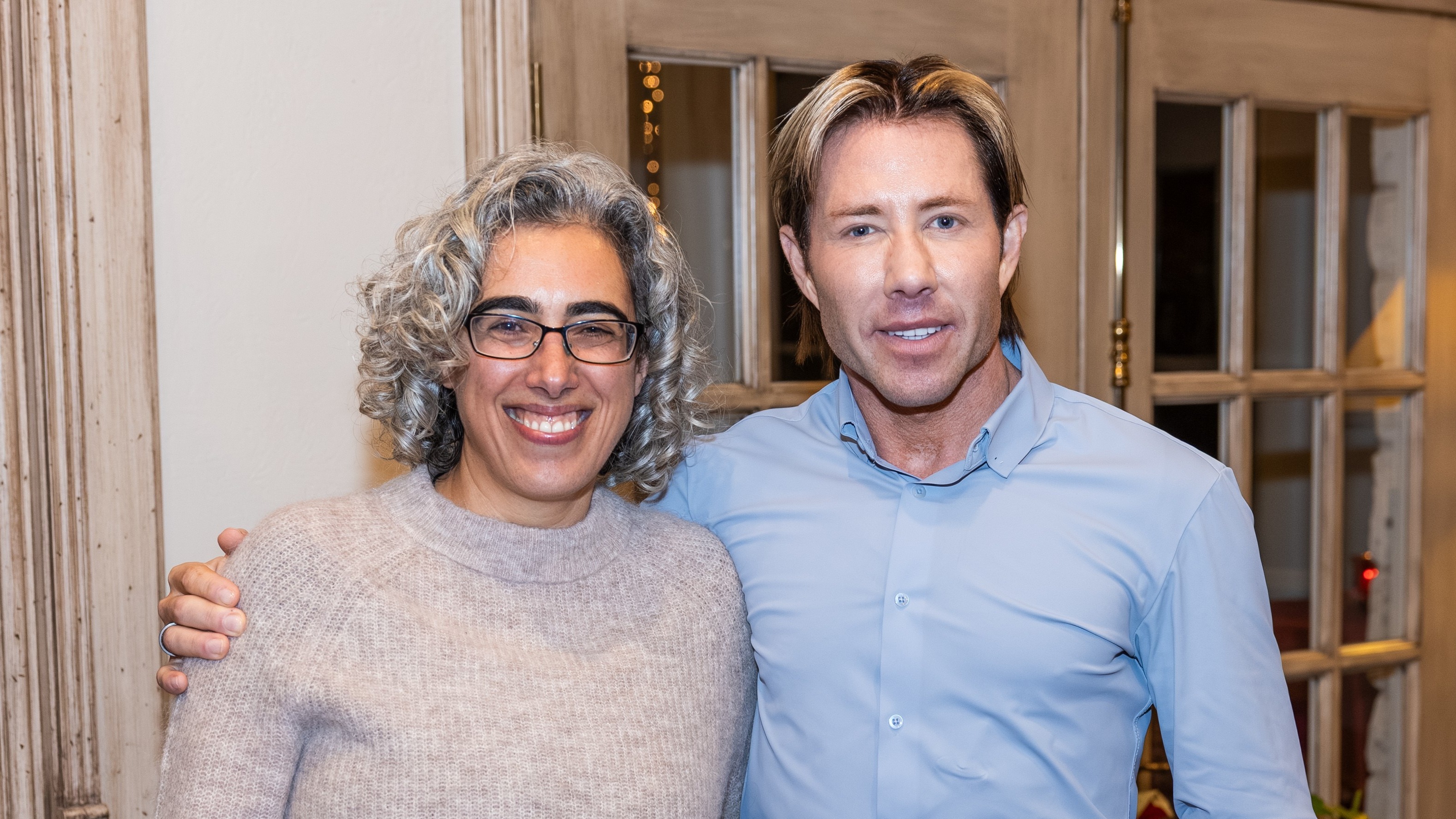 Sleep scientists Eti Ben Simon, PhD, and Matt Walker, PhD, pose for a photo at a warmly lit reception, celebrating the launch of the Sleep Innovation Laboratories at Center for BrainHealth, part of UT Dallas.