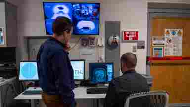 Over the shoulder shot of Sergey (left) and Jason (right) in the MRI command center