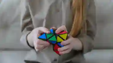 A girl with long blonde hair is solving a triangle puzzle