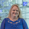 Lori Cook in a blue blouse with blue lights, portrait. Director of Clinical Research, BrainHealth Research; Head of Research, The BrainHealth Project; Adjunct Assistant Professor, School of Behavioral and Brain Sciences