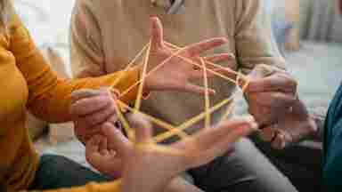 A multigenerational family plays the string game cat's cradle.