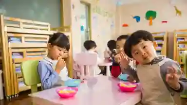 Three asian children enjoying lunch in their classroom