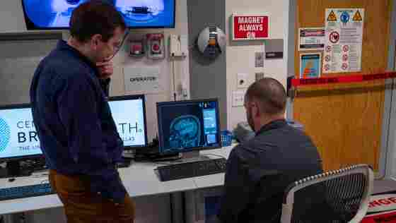 Over the shoulder shot of Sergey (left) and Jason (right) looking at brain imaging