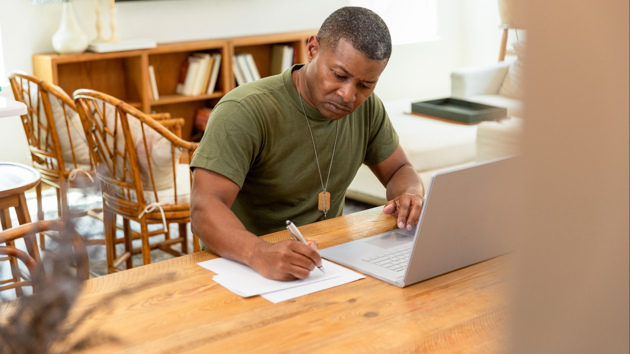 Mature military veteran works on a laptop at home to engage in science-backed brain training to enhance clarity, resilience and executive function.