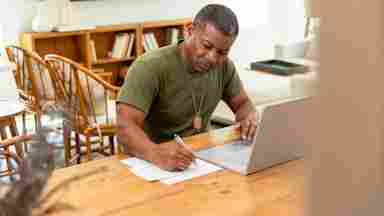 Mature military veteran works on a laptop at home to engage in science-backed brain training to enhance clarity, resilience and executive function.