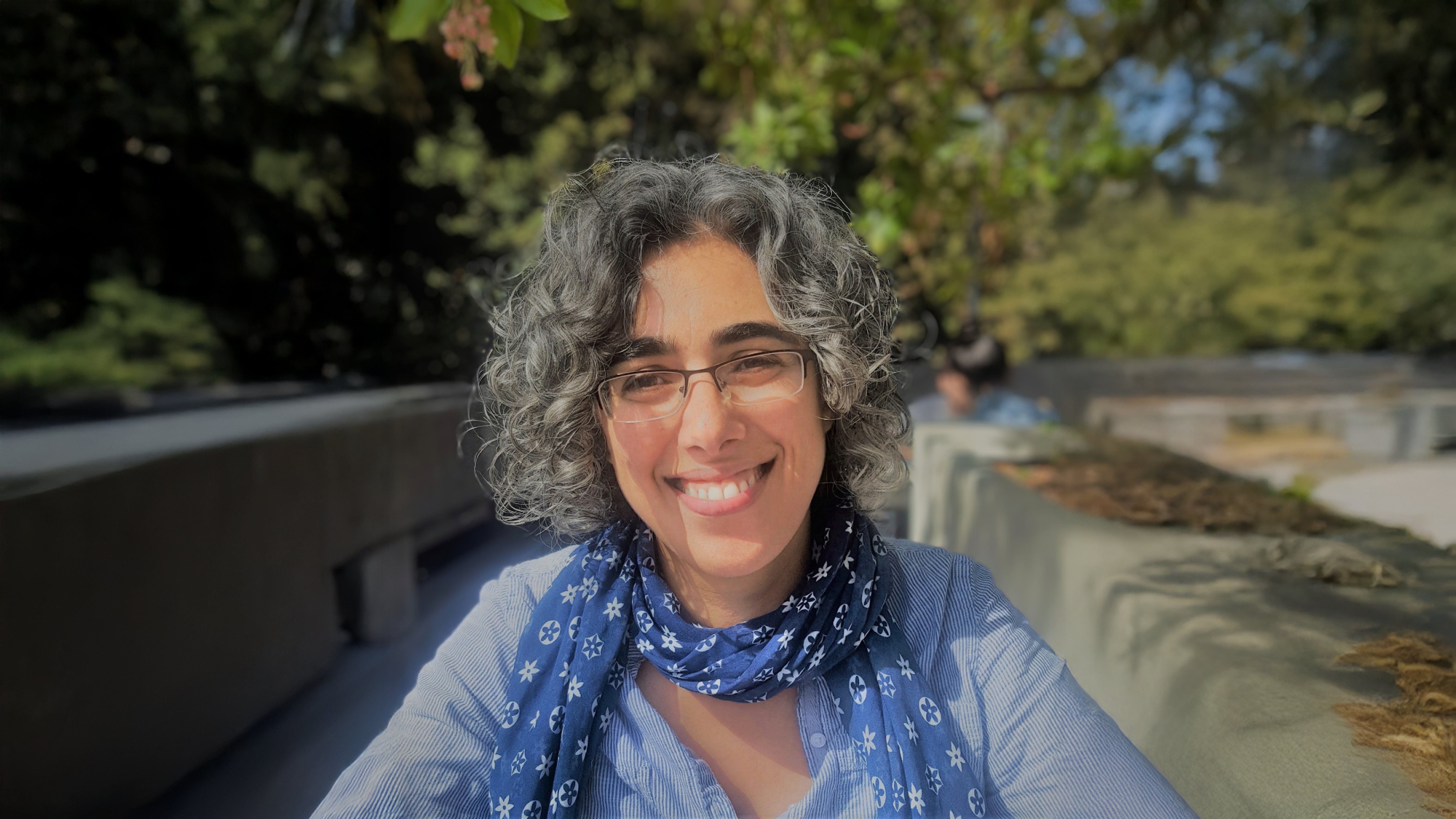Photograph of neuroscientist Eti Ben Simon, PhD. in a lush outdoor setting