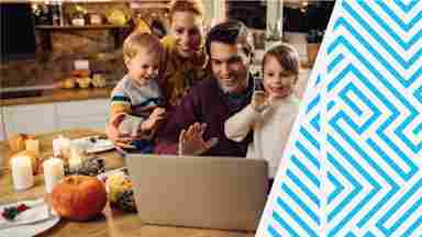 A smiling family waving at loved ones during a remote video call.