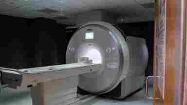 Wide-shot shot (5) of an MRI Machine in imaging center. Door shows. 