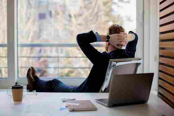 Businessman resting in an office and looking out the window at nature.