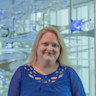 Lori Cook in a blue blouse with blue lights, portrait. Director of Clinical Research, BrainHealth Research; Head of Research, The BrainHealth Project; Adjunct Assistant Professor, School of Behavioral and Brain Sciences