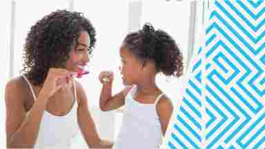 A mother and child happily brushing their teeth together.