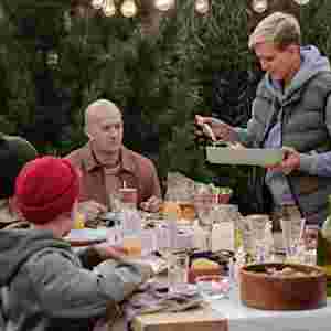 Multi generational family eating dinner outdoors.