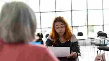 A college student and their teacher discuss results from an assignment.