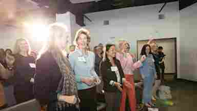 Attendees at the Empower Women Through Brain Health conference get up and dance during a series of talks about improving women's health through neuroscience.