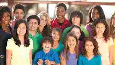 A diverse group of youths/children smiling into the camera.