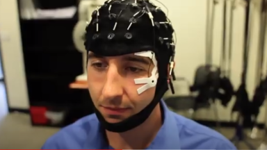 A man wearing an EEG (electrical simulation and measure) headset.