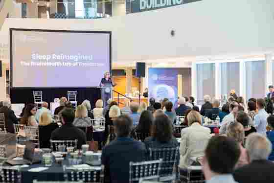 Neuroscientist and sleep expert Eti Ben Simon, PhD, of UT Dallas speaks at BrainHealth Week 2026, on stage at Center for BrainHealth in Dallas, Texas, in front of a large screen saying, "Sleep Reimagined."