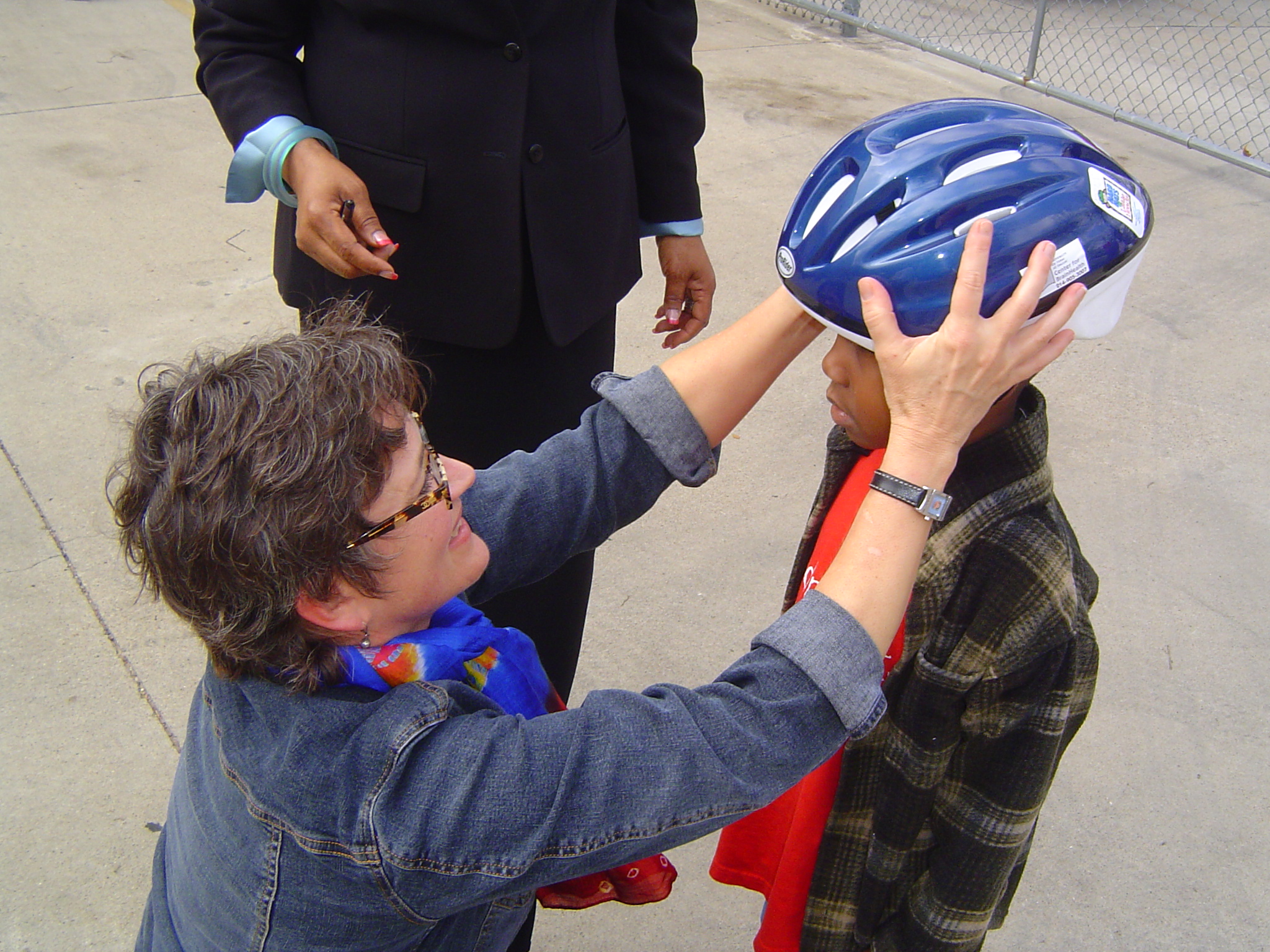 A clinician at Center for BrainHealth places helmet on child's head in order to prevent and raise awareness of youth traumatic brain injuries.