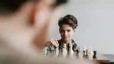 Over the shoulder shot of a man and child playing chess