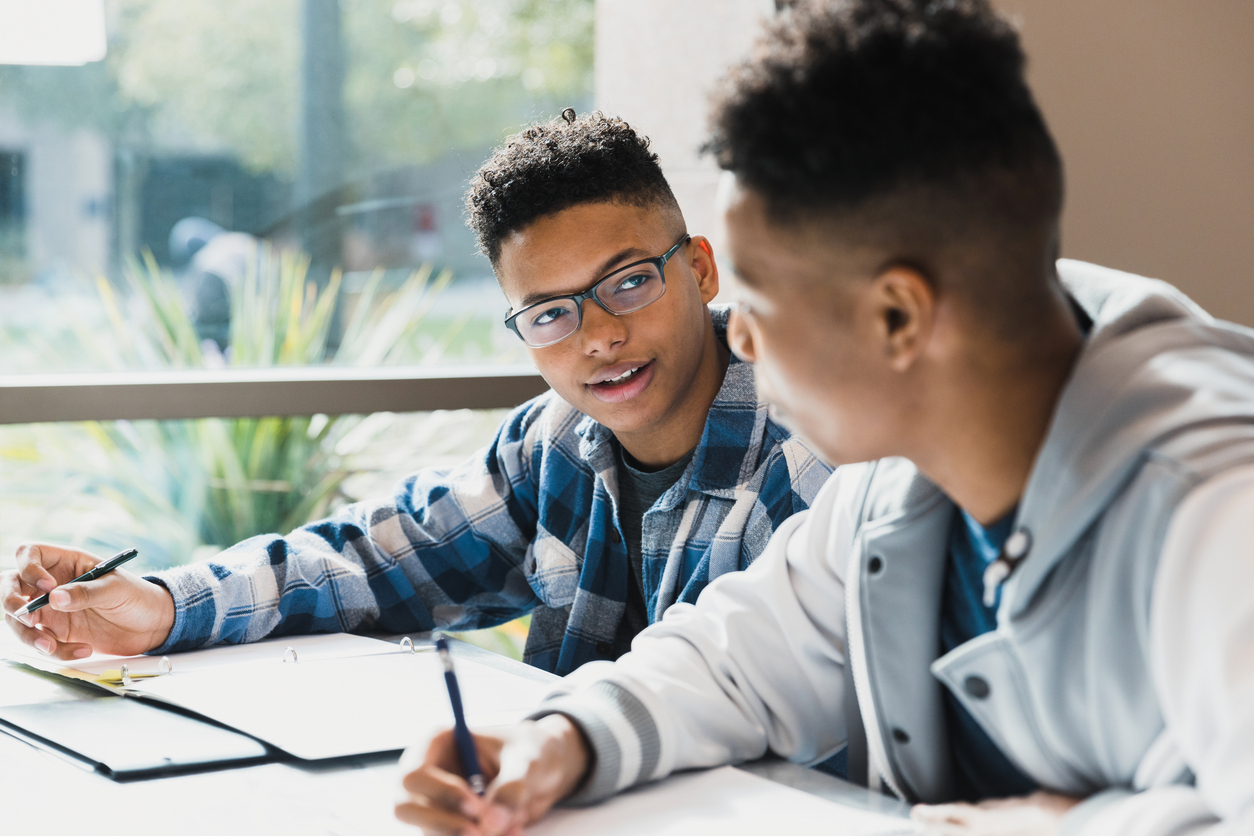 Teenage boys talk as the friends study for a test together.