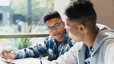 Teenage boys talk as the friends study for a test together.
