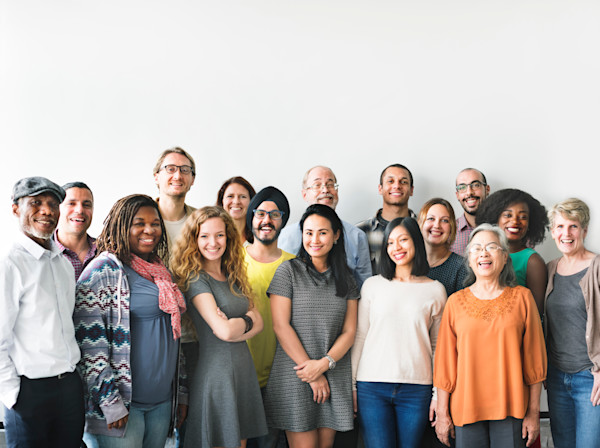 A diverse group of adults smiling into the camera.