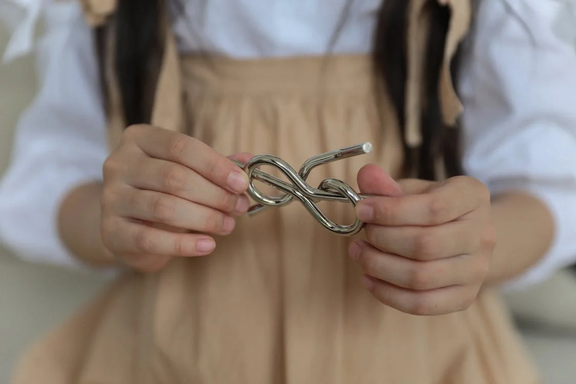 Little girl holding a metal knot puzzle