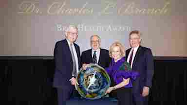 Sandi Chapman, PhD, alongside world‑renowned physician‑scientist Dr. Francis Collins, who led the international Human Genome Project and later the NIH, and the sons of Dr. Charles L. Branch, at the 2026 Branch BrainHealth Award, honoring Dr. Collins' contributions to neuroscience.