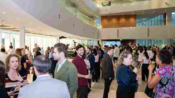Guests fill the bright, modern atrium of Center for BrainHealth's Brain Performance Institute during a bustling and energetic VIP reception.
