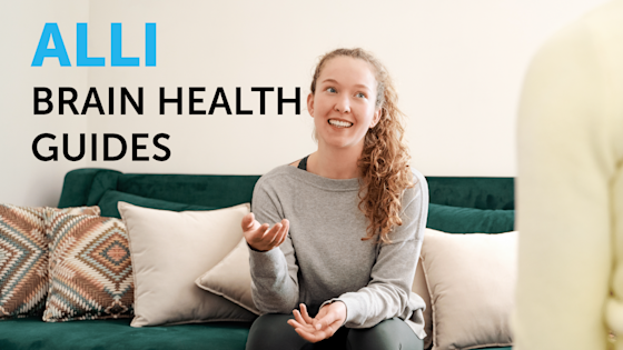 A smiling college student with curly hair sits on a teal sofa gesturing to a trusted adult to the side of the frame, beside text reading "Alli Brain Health Guides."