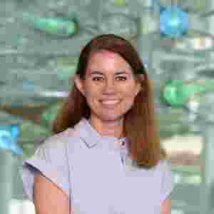 Jennifer Zientz in a light blue blouse with green and blue lights, vertical. Head of Clinical Services; Deputy Director, Performance
