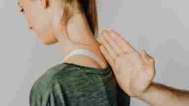 A picture of a girl with a hand on her back.