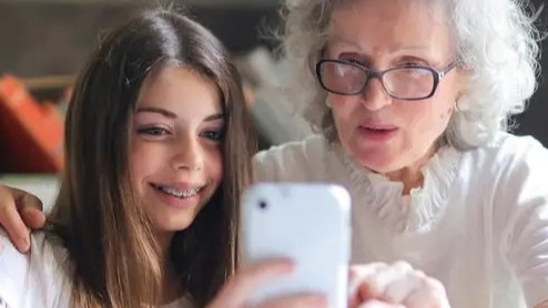 A young teen and grandparent work together happily.