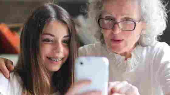 A young teen and grandparent work together happily.